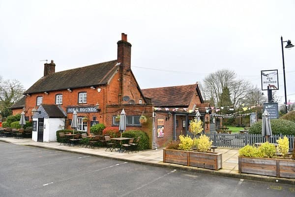 The Fox and Hounds in Tadley, a red brick pub with bunting strung over the tables outside it.